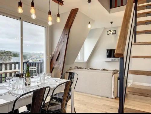 - une salle à manger avec une table et des verres à vin dans l'établissement Le Duplex - Deauville, à Deauville