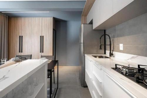 a kitchen with white counters and a counter top at ZEE Studios by Viva - Studios a 200m da beira-mar norte in Florianópolis