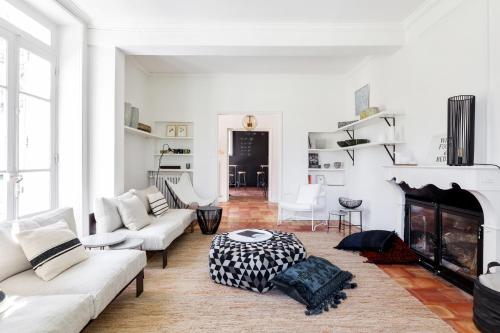 a living room with white furniture and a fireplace at Le Pont de L'orme in Malaucène