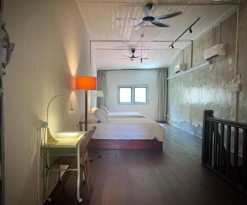 a bedroom with a bed and a desk and a window at LEJU 79 樂居 Heritage Living in Melaka