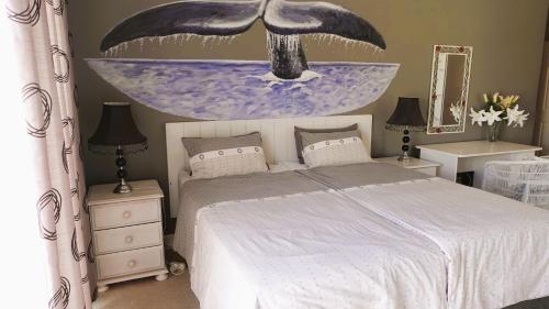 a bedroom with a bed and a painting on the wall at Big6 Guesthouse in Somerset West