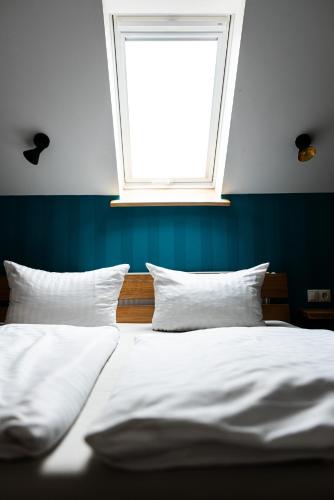 a bedroom with two white beds and a window at Landkulturhof Glücksbringer in Rudolstadt