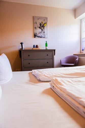 a hotel room with two beds and a dresser at Landkulturhof Glücksbringer in Rudolstadt