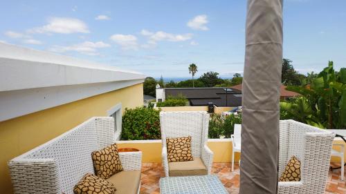 a group of chairs sitting on a patio at Big6 Guesthouse in Somerset West