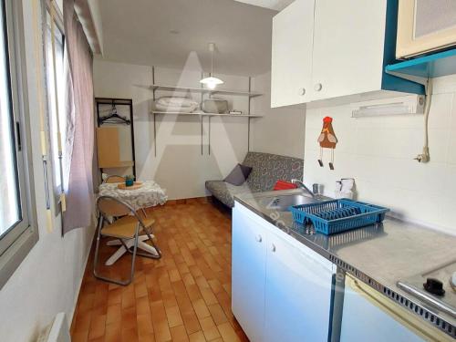 une cuisine avec un évier et un plan de travail dans l'établissement Studio entre vie de quartier et plages, à Sète