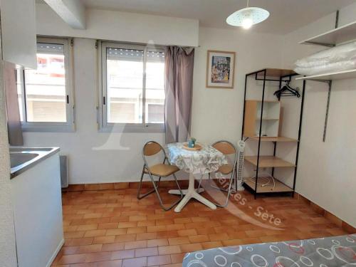 une cuisine avec une table et des chaises dans une pièce dans l'établissement Studio entre vie de quartier et plages, à Sète