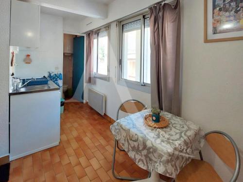 une petite table dans une cuisine avec une table et des chaises dans l'établissement Studio entre vie de quartier et plages, à Sète