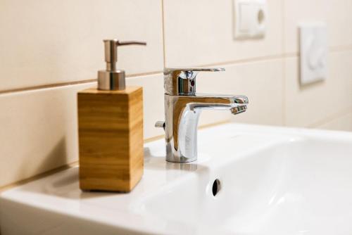a bathroom sink with a faucet and a wooden holder at Landkulturhof Glücksbringer in Rudolstadt