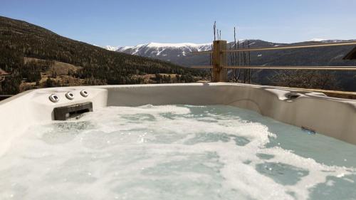 a jacuzzi tub with a view of a mountain at Luxus Alpin Chalet & Traumblick Nockberge auf H1200m in Plessnitz