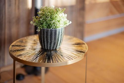 a vase on a table with a plant on it at Luxus Alpin Chalet & Traumblick Nockberge auf H1200m in Plessnitz