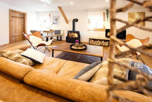 a living room with a couch and a fireplace at Luxus Alpin Chalet & Traumblick Nockberge auf H1200m in Plessnitz