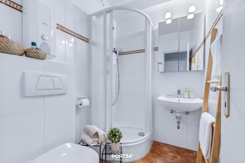 a white bathroom with a shower and a sink at Ferienwohnung Sydvind 8408 Marina Wendtorf in Wendtorf
