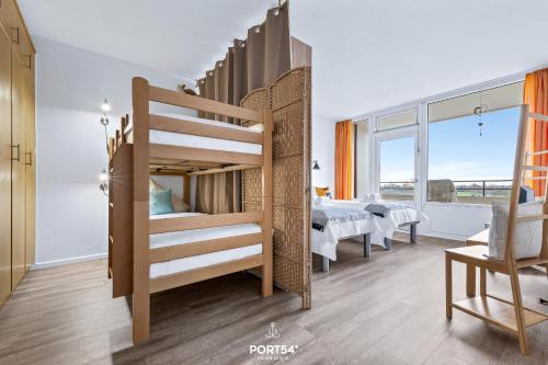 a bedroom with a bunk bed and a dining room at Ferienwohnung Sydvind 8408 Marina Wendtorf in Wendtorf