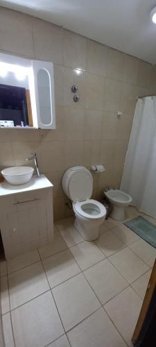 a bathroom with a toilet and a sink and a shower at Casa Acacias in Sierra de la Ventana