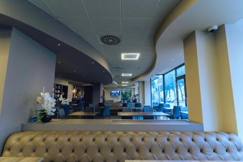 a waiting room with blue chairs and tables at DC HOTEL INTERNATIONAL in Padova
