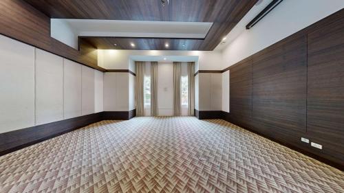 an empty room with wood paneled walls and a hallway at Gurmon Hotels Sohna Road Gurugram, a member of Radisson Individuals in Sohna