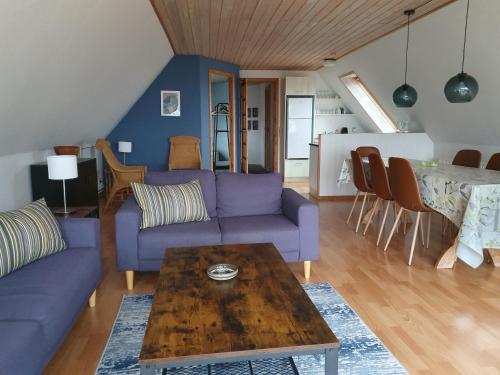 a living room with a purple couch and a table at Feriestedet Skovly in Klemensker