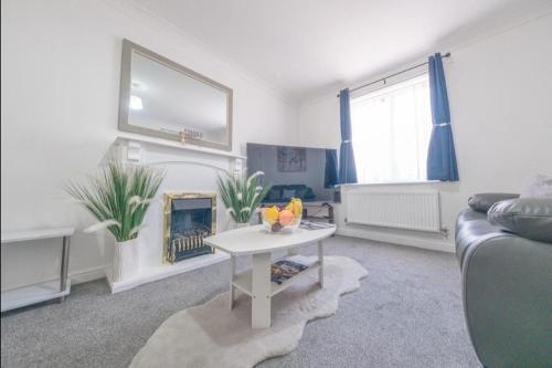 a living room with a couch and a fire place at Sleeps 5 - Private Garden- Free Parking in Corby