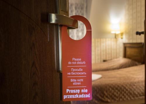 a sign on the door of a hotel room at Dwór Ostoia in Rymanów