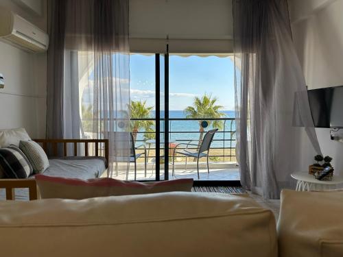 a living room with a couch and a view of the ocean at Krasas Beach in Larnaka