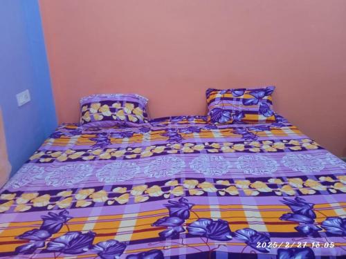 a bed with a colorful comforter and pillows at Swastik HomeStay in Ayodhya