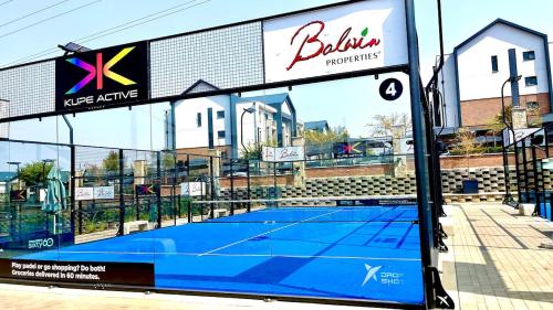 a tennis court in front of a building at The Sanctuary Sleek Smart Space in Johannesburg