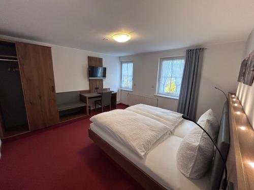 a hotel room with a bed and a desk at Landhof Grewen Mühle in Meschede