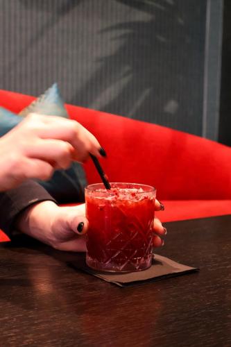 a woman is holding a drink with a straw at Hotel Collingwood BW Signature Collection in Bournemouth
