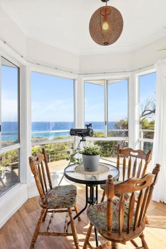 a dining room with a table and chairs and the ocean at Salt & Peppermint - Beachfront Escape with Stunning Views in Capel