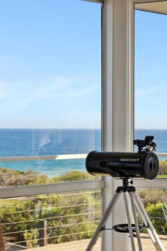 a camera on a tripod in front of a window at Salt & Peppermint - Beachfront Escape with Stunning Views in Capel