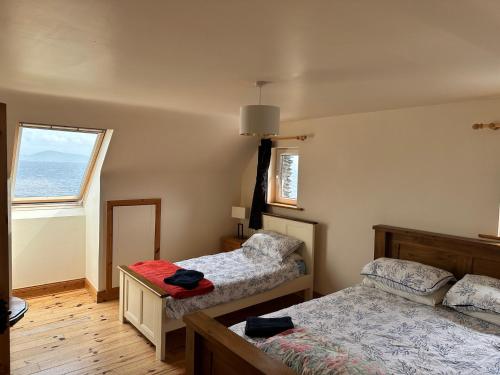 a bedroom with two beds and a window at Ryan's Seaside Escape - Entire House On the Ocean in Caherdaniel