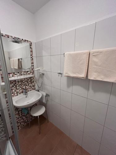 a white bathroom with a sink and a mirror at Landhof Grewen Mühle in Meschede