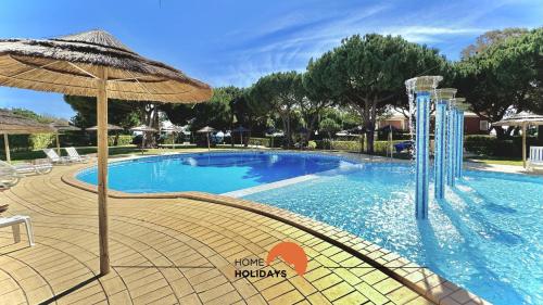 a large swimming pool with an umbrella and chairs at #269 T2 Bicos Flat R by Home Holidays in Albufeira