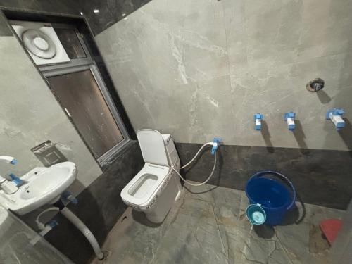 a bathroom with a white toilet and a sink at Yuvraj Guest house in Khātu