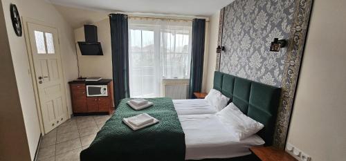 a bedroom with a green bed with two towels on it at Apartamenty Hexagon nr 32 in Grzybowo