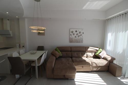 een woonkamer met een bank en een tafel bij Fabulous Villa with private pool & large roof solarium in Villamartin