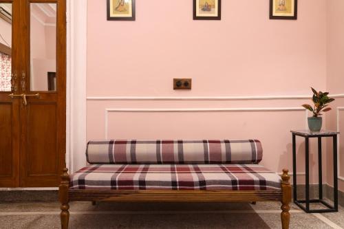 a bench in a room with a white wall at House of Amer in Jaipur