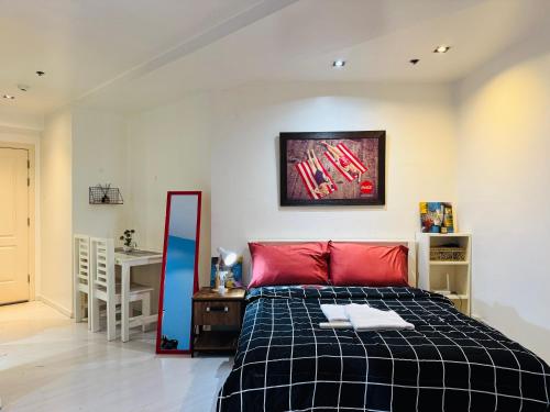 マニラにあるThe Gramercy Residencesのベッドルーム(黒と赤のベッド1台、デスク付)