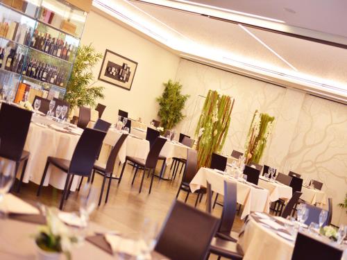 a dining room with white tables and chairs at AS Hotel Limbiate Fiera in Limbiate