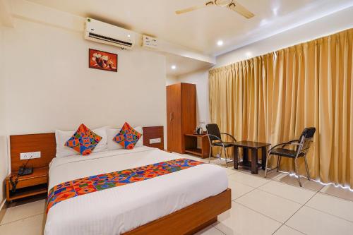 a bedroom with a bed and a table with chairs at FabHotel The Prime - Nr Horamavu in Bengaluru