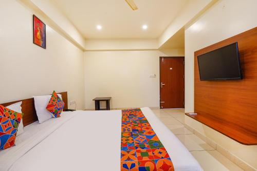 a bedroom with a bed and a flat screen tv at FabHotel The Prime - Nr Horamavu in Bengaluru