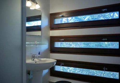 une salle de bain avec un lavabo et deux fenêtres dans l'établissement Appartement accès direct à la mer, à Bormes-les-Mimosas