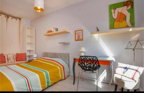 une chambre avec un lit, un bureau et une chaise dans l'établissement Beau F2 au coeur de Hyères, à Hyères