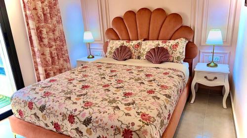 a bedroom with a large bed with a floral bedspread at Super Apartement in Martil