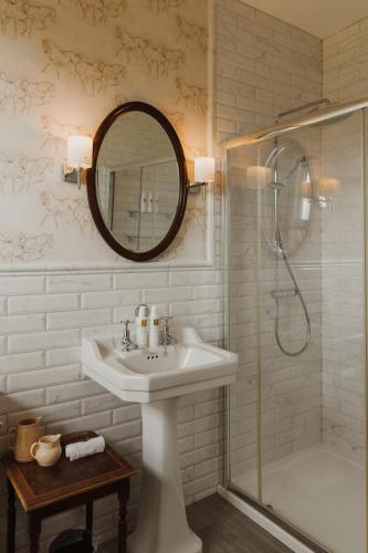a white bathroom with a sink and a shower at Cartmel Old Grammar in Cartmel