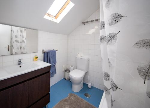 a bathroom with a toilet and a shower curtain with umbrellas at Casa Moniz - 4 floor in Lisbon