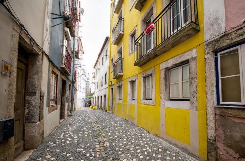 an empty alley with yellow walls in a city at Casa Moniz - 4 floor in Lisbon