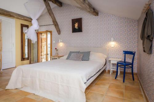 - une chambre avec un lit blanc et un mur bleu dans l'établissement Gite La Loge - Chateau Mondou, à Villeneuve-sur-Lot