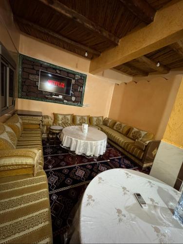 a room with couches and a table and a tv at Scenic Lakeview House Near 5-Star Widian Hotel in Bine el Ouidane