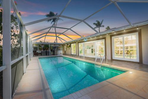 an indoor swimming pool in a house with a building at Gulf Breeze Haven Direct Gulf Access Pool+Dock in Cape Coral